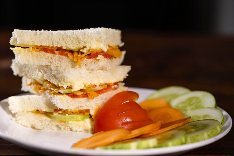 A veg sandwich with tomato, cucumber and carrot